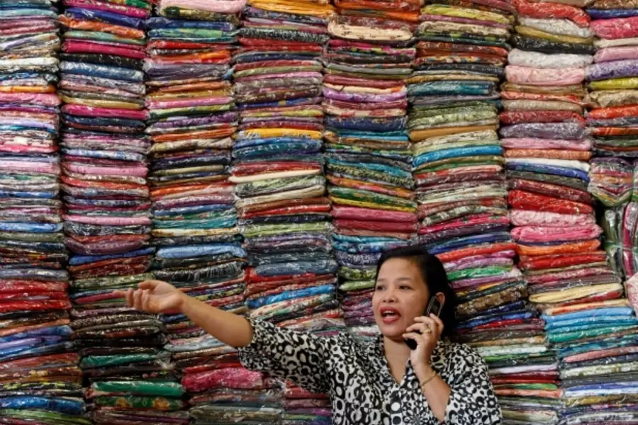 Fadhilah Arshad, a Malaysian businesswoman, talks to a supplier as she sells cloth at her bazaar in Kuala Lumpur, December 2009. (Courtesy Reuters/Bazuki Muhammad).
