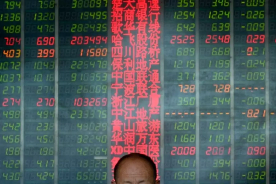 An investor in front of an electronic board showing stock information at a brokerage house in Taiyuan, Shanxi province, May 9, 2013 (Courtesy Reuters/Jon Woo).