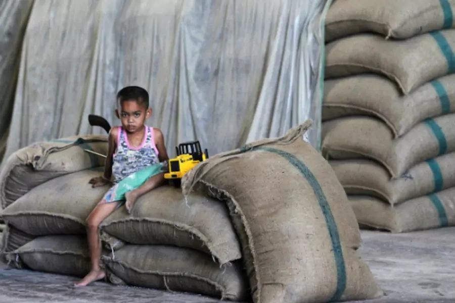 A child sits on a bag of milled rice at a mill in Suphan Buri province, north of Bangkok on March 11, 2013. Thailand was set t...eteriorating in quality in warehouses filled with grain bought under a government scheme. (Chaiwat Subprasom/Courtesy Reuters)