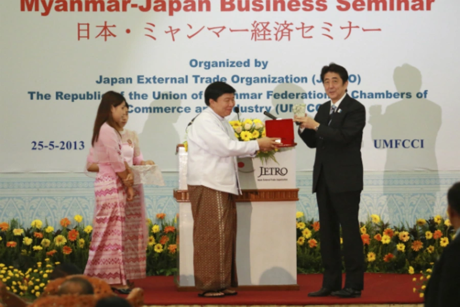 Japan's Prime Minister Shinzo Abe accepts a gift from Win Aung, the chairman of the Union of Myanmar Federation of Chambers of...y (UMFCCI), at a Myanmar-Japan business seminar at the UMFCCI premises in Yangon on May 25, 2013. (Stringer/ Courtesy Reuters)