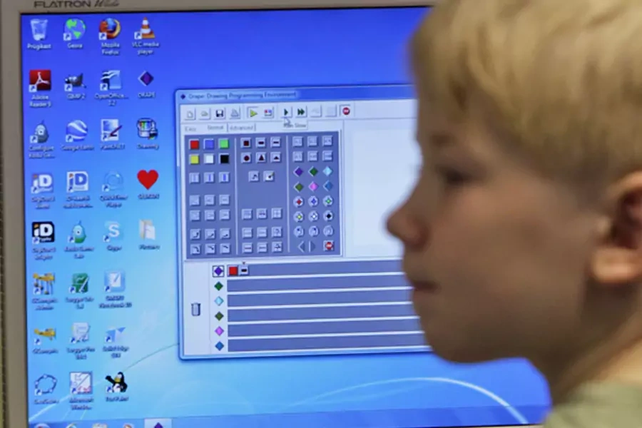 A first grade student listens during a computer lesson in school (Courtesy Reuters).
