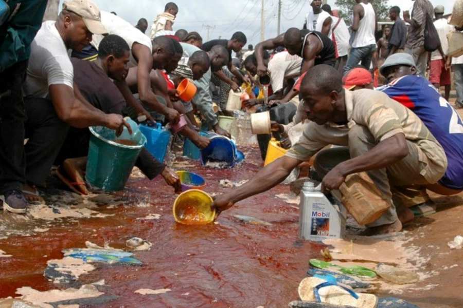 Nigerians scoop petrol after a Nigerian National Petroleum Corporation pipeline burst in April 2006 (Courtesy Reuters).