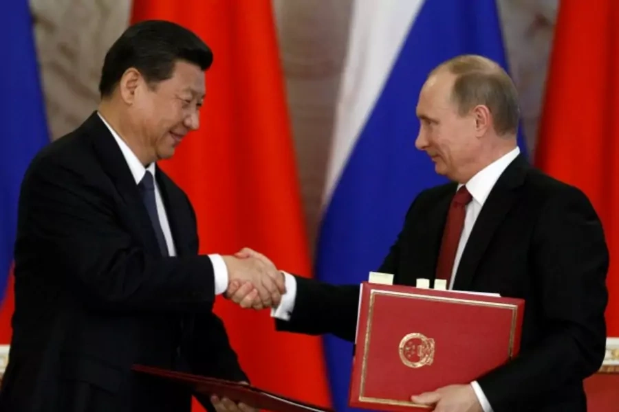 Russia's President Vladimir Putin (R) exchanges documents with his Chinese counterpart Xi Jinping during a signing ceremony at the Kremlin in Moscow on March 22, 2013.