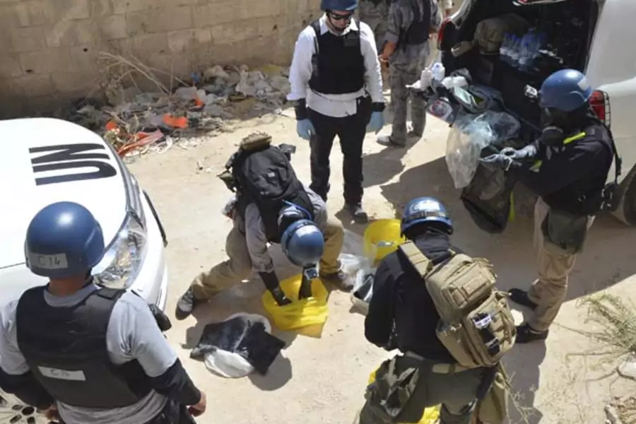 UN chemical weapons experts prepare to collect samples from an alleged site of a chemical weapons attack in the Damascus suburb of Zamalka (Bassam Khabieh/Courtesy Reuters).