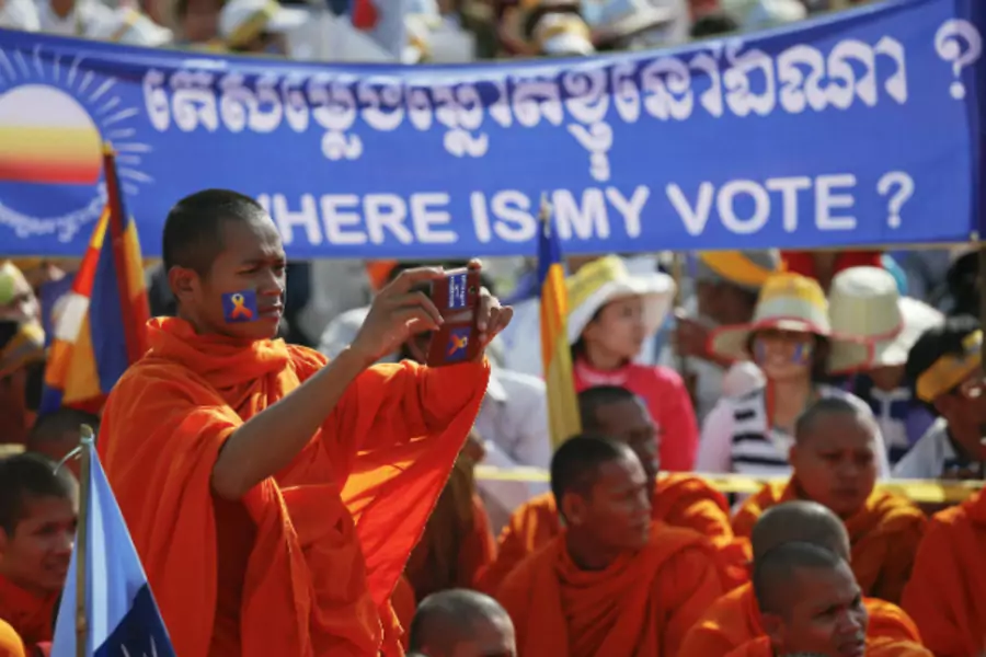 A Buddhist monk records the speech of one of the leaders of Cambodia National Rescue Party (CNRP) during a rally in Phnom Penh on September 7, 2013. (Damir Sagolj/Courtesy Reuters)