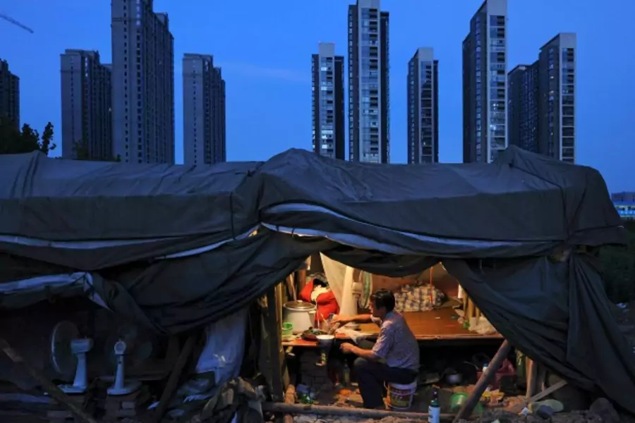 A labourer has his dinner under his shed at a construction site of a residential complex in Hefei, Anhui province, August 1, 2012. (Stringer/Courtesy Reuters)