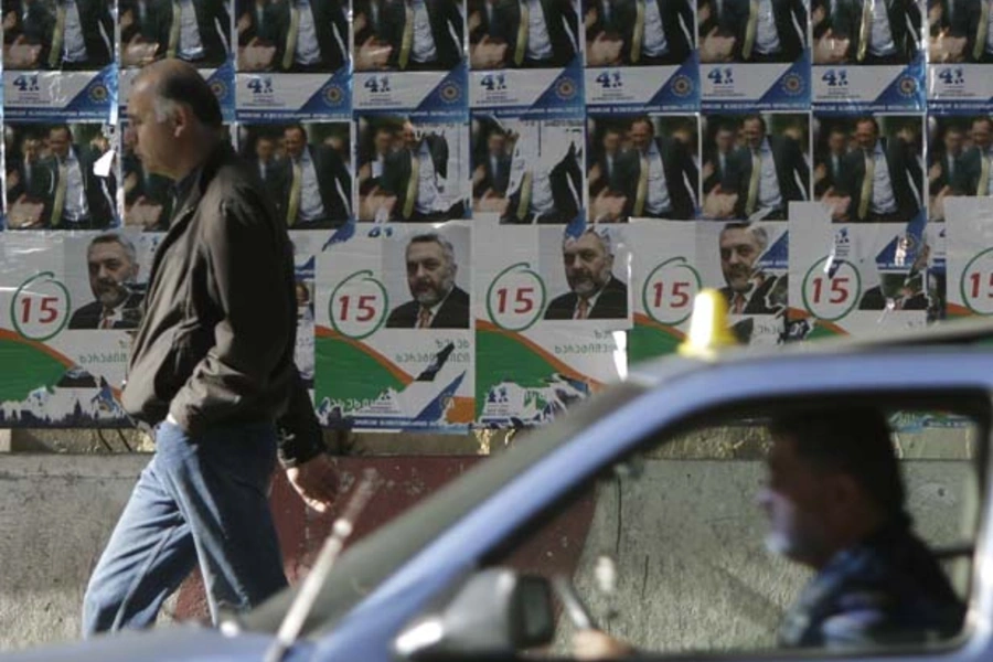 A man passes campaign posters in Tbilisi, Georgia (David Mdzinarishvili/Courtesy Reuters).