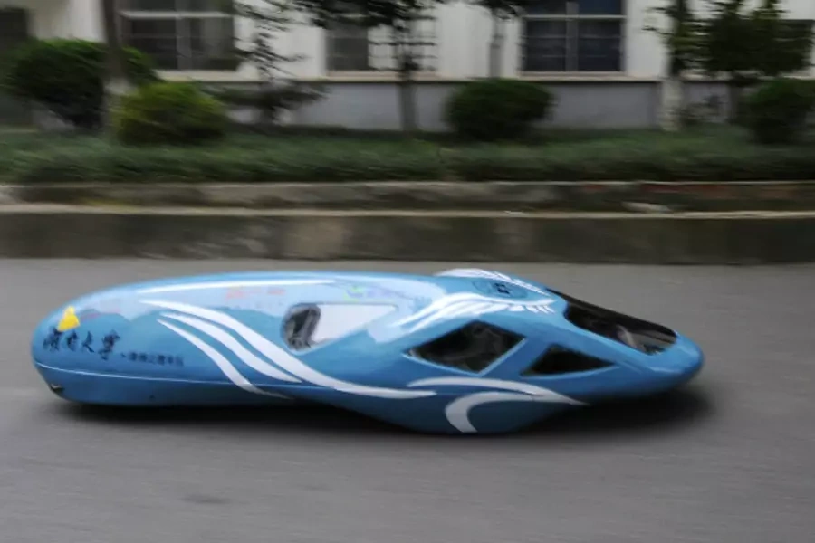 A newly-made fuel-efficient vehicle travels along a street inside the Hunan University during a test drive in Changsha, Hunan province October 8, 2013.