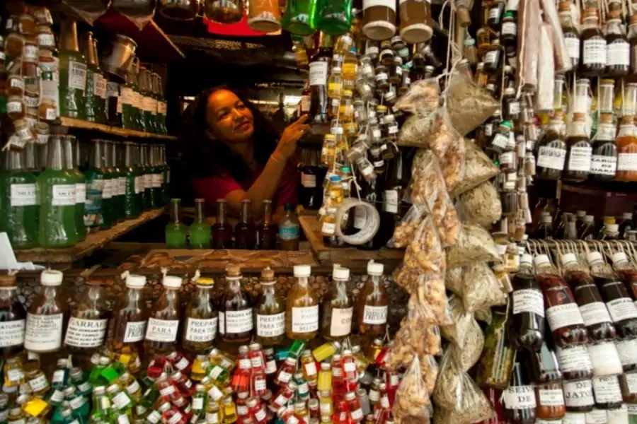 A shopkeeper arranges her bottles of perfumes and oil in Belem, Brazil, January 2011 (Courtesy Reuters/Paulo Santos).