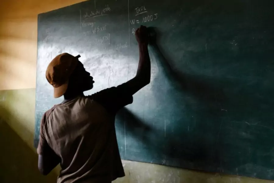 A student writes on a blackboard in a classroom outside of Lome, Togo, April 2013. (Courtesy Reuters/Darrin Zammit Lupi).