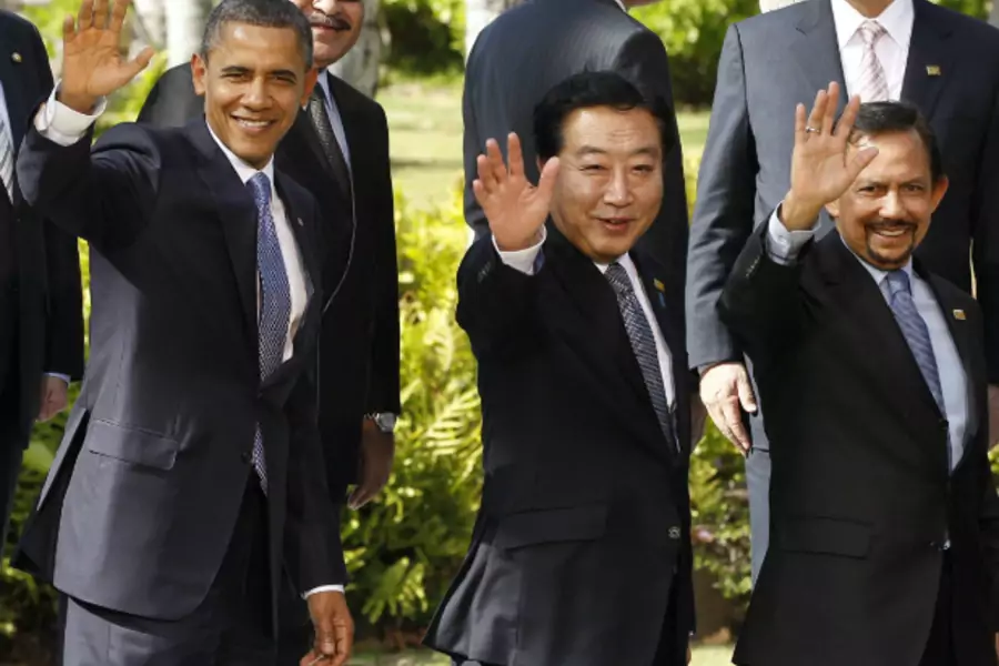 U.S. President Barack Obama, Japan's Prime Minister Yoshihiko Noda and Brunei's Sultan Hassanal Bolkiah wave during a leaders' family photo at the APEC Summit in Honolulu, Hawaii on November 13, 2011. (Jason Reed/Courtesy Reuters)