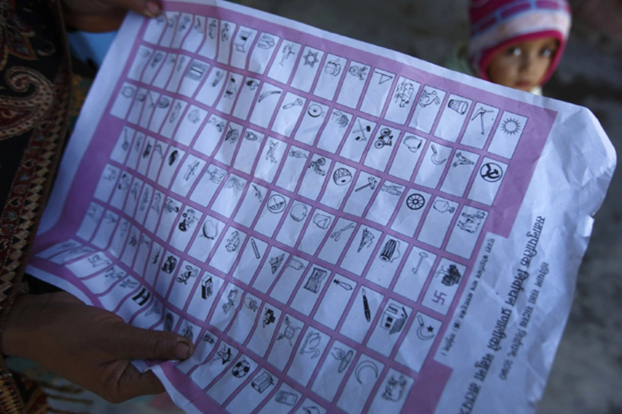 A woman holds a ballot paper during the election campaign of Nepali Congress Party in Kathmandu November 15, 2013