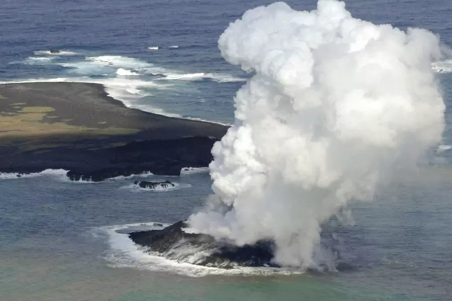 Smoke from an erupting undersea volcano forms a new island off the coast of Nishinoshima (top L), a small uninhabited island, in the southern Ogasawara chain of islands in this November 21, 2013