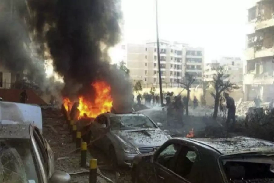 Civil Defence personnel extinguish a fire on cars at the site of the explosions near the Iranian embassy in Beirut November 19, 2013 (Yassine/Courtesy Reuters).