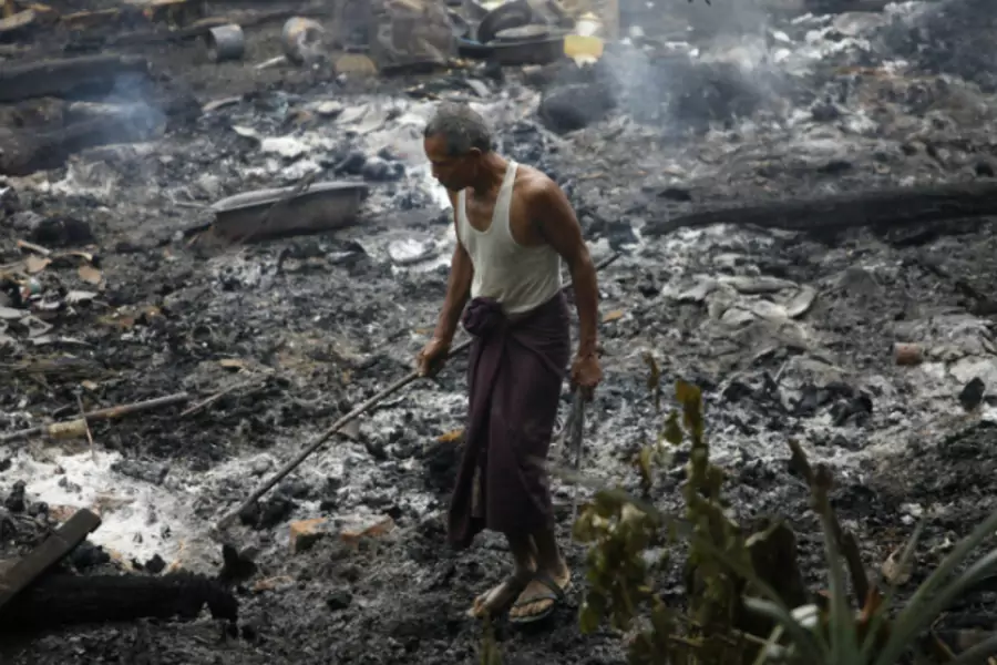 A Muslim man searches for his belongings left behind of his burnt home at Thapyuchai village, outside of Thandwe in the Rakhine state, on October 2, 2013. (Soe Zeya Tun/Courtesy Reuters)