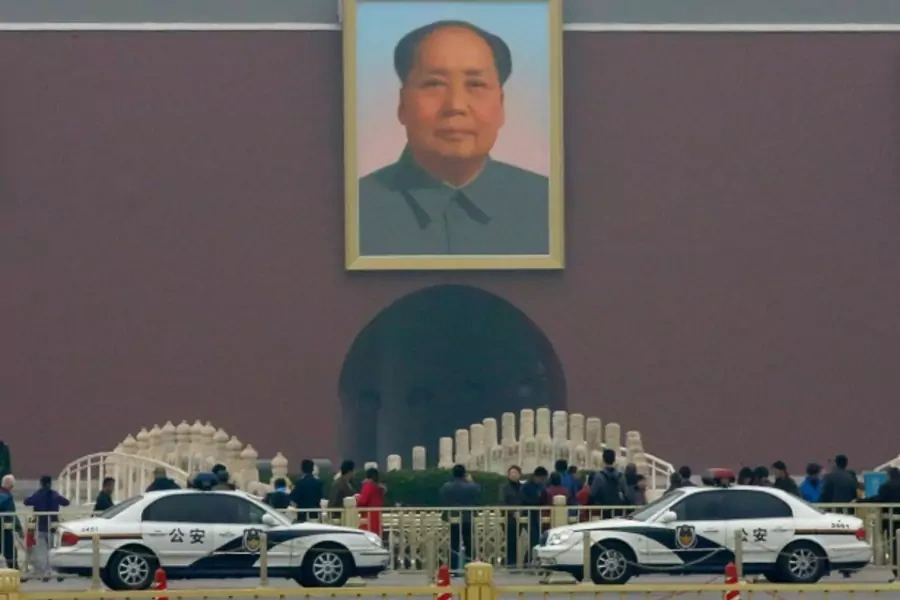 Police cars are parked in front of a giant portrait of late Chinese Chairman Mao Zedong at the main entrance of the Forbidden City in Beijing on November 1, 2013 (Kim Kyung-Hoon).