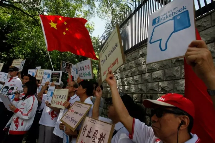 Demonstrators from the pro-China "Caring Hong Kong Power" group protest over claims from former U.S. spy agency contractor Edw...cked computers in the Chinese territory, outside the U.S. Consulate in Hong Kong on July 9, 2013. (Bobby Yip/Courtesy Reuters)