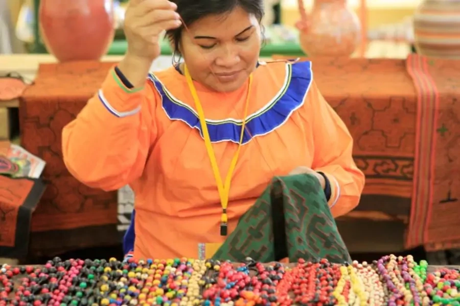 A woman from the Amazon region weaves a textile in Lima, Peru, July 2012 (Courtesy Reuters/Enrique Castro-Mendivil).