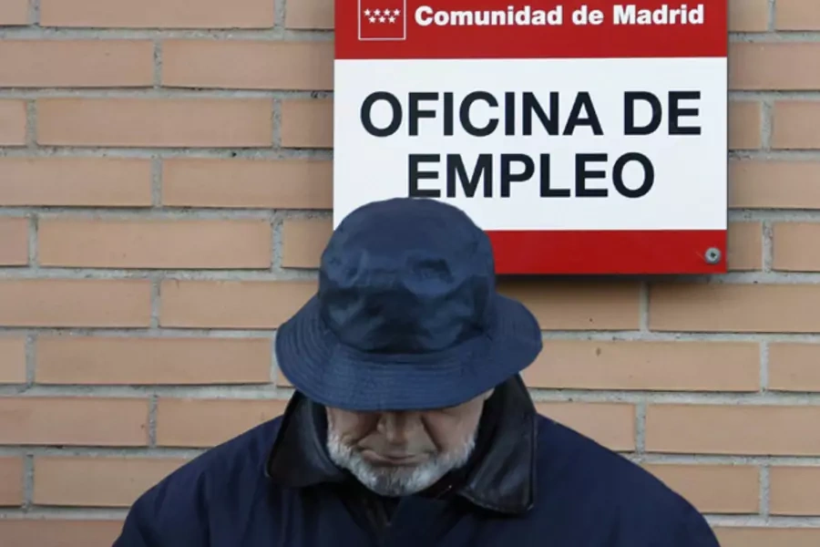 A man looks down as he waits in line to enter a government-run employment office in Madrid (Sergio Perez/Courtesy Reuters).
