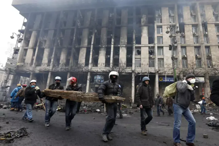 Anti-government protesters carry logs to build barricades after violence erupted in the Independence Square in Kiev, Ukraine. (Vasily Fedosenko/Courtesy Reuters)