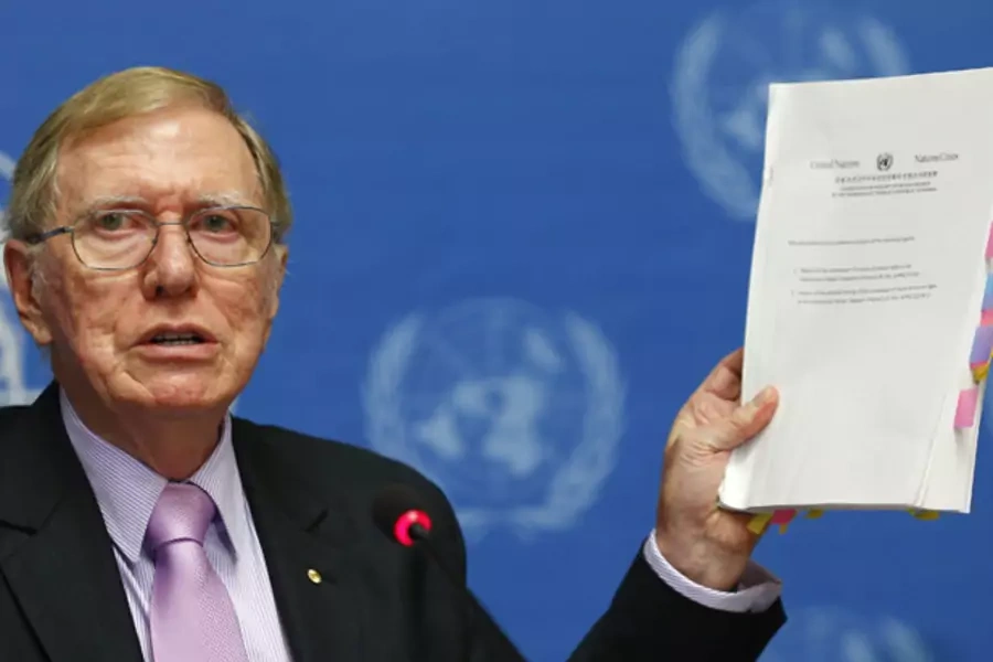 Michael Kirby, Chairperson of the Commission of Inquiry on Human Rights in North Korea holds a copy of his report during a news conference at the United Nations in Geneva February 17, 2014