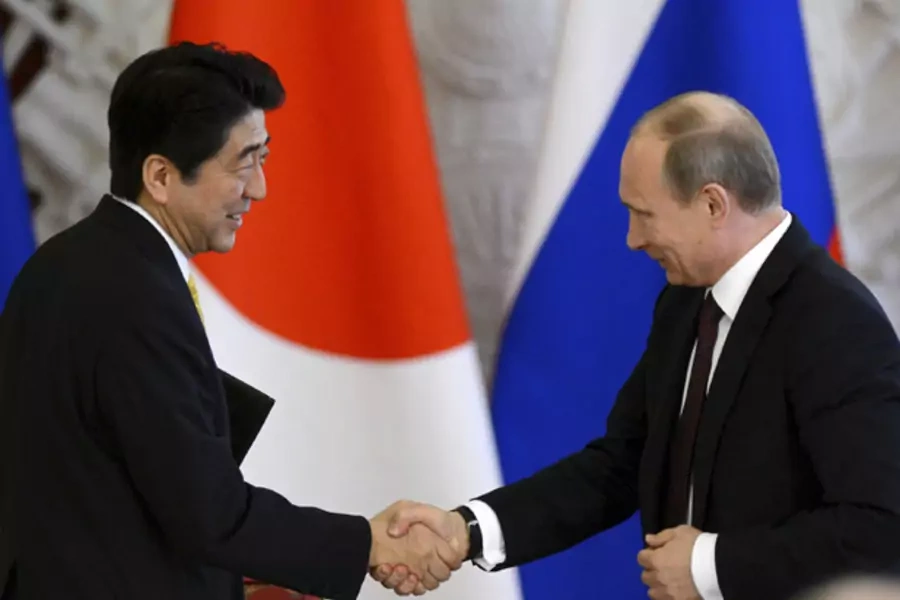 Russia's President Vladimir Putin (R) shakes hands with Japan's Prime Minister Shinzo Abe during a signing ceremony at the Kre...e participation in gas projects in Russia. REUTERS/Kirill Kudryavtsev/Pool (RUSSIA - Tags: POLITICS BUSINESS ENERGY) - RTXZ3HU