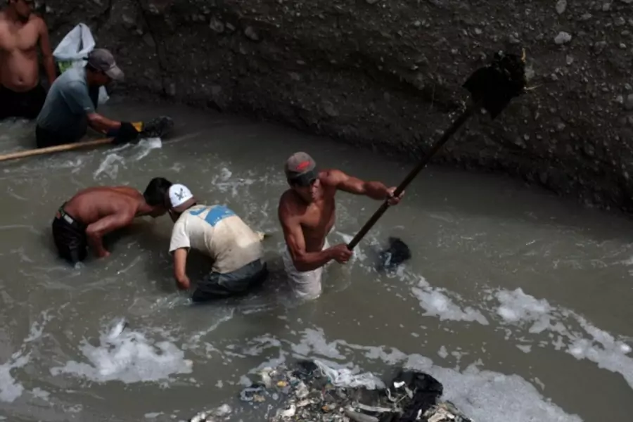 Men look for metals and other valuables in the waste waters of the city dump in Guatemala City, Guatemala, September 2011 (Courtesy Reuters/Jorge Dan Lopez).