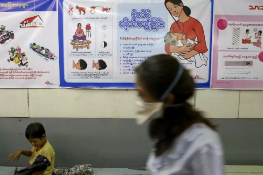 A nurse walks past as a child sitting at Medecins Sans Frontieres Holland's clinic in Yangon on March 3, 2014. (Minzayar Minzayar/Courtesy Reuters)