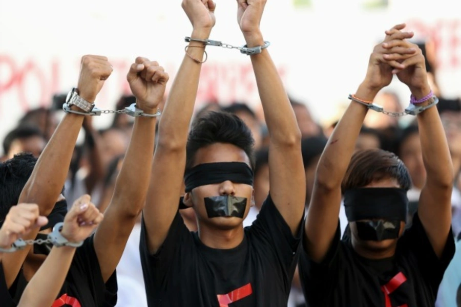 Demonstrators handcuff their wrists and tape their eyes and mouths while taking part in a protest calling for changes to the constitution. Yangon, Myanmar, January 2014 (Courtesy Reuters/Stringer).