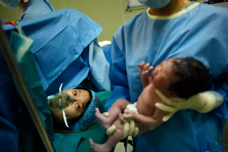 Yang Huiqing looks at her baby after a cesarean section in Ruijin Hospital in Shanghai