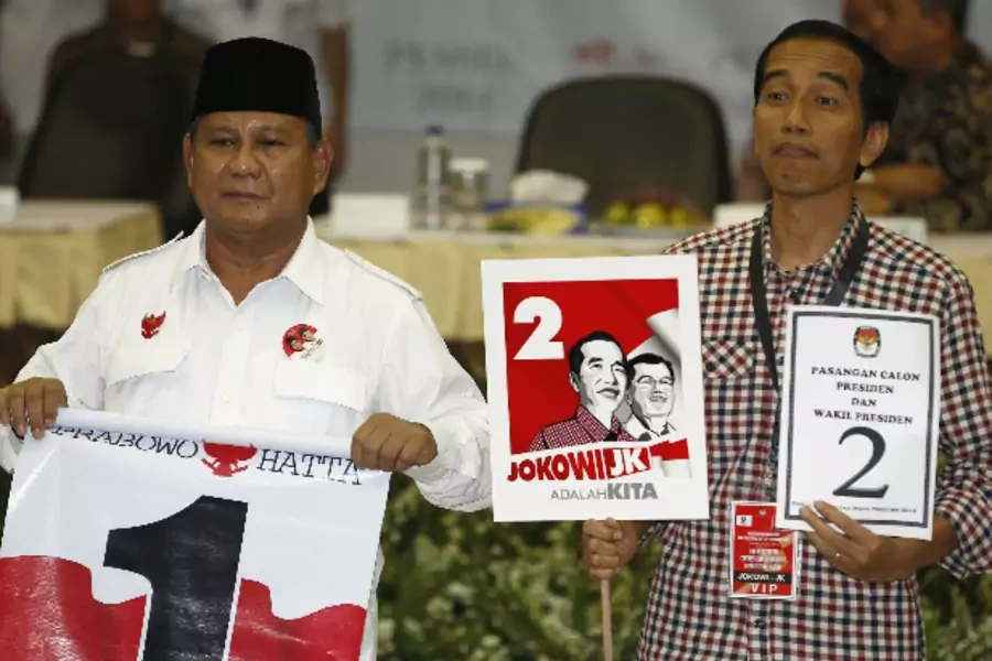 Indonesian presidential candidates Prabowo Subianto (L) and Joko "Jokowi" Widodo hold their ballot numbers after drawing them at the Election Commission in Jakarta on June 1, 2014 (Stringer/Courtesy: Reuters).