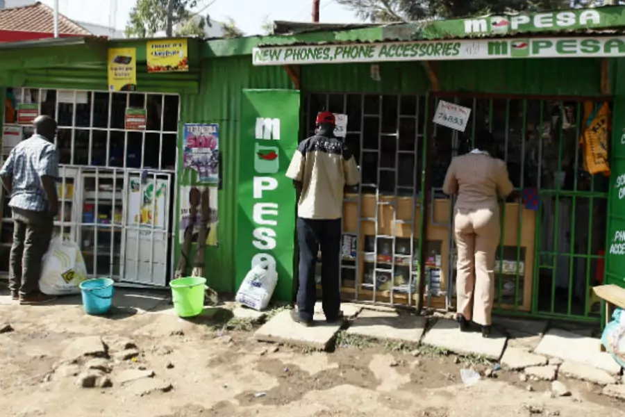 Customers are seen at mobile money transfers kiosks, known as M-Pesa agents, near Ngong township in the outskirts of Kenya's capital Nairobi, July 15, 2013 (Courtesy Reuters/Thomas Mukoya).