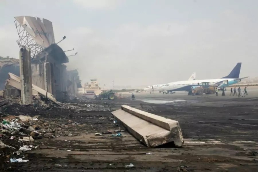 Planes are seen near a section of a damaged building (L) at Jinnah International Airport, after Sunday's attack by Taliban militants, in Karachi June 10, 2014. (Athar Hussain/Courtesy Reuters)