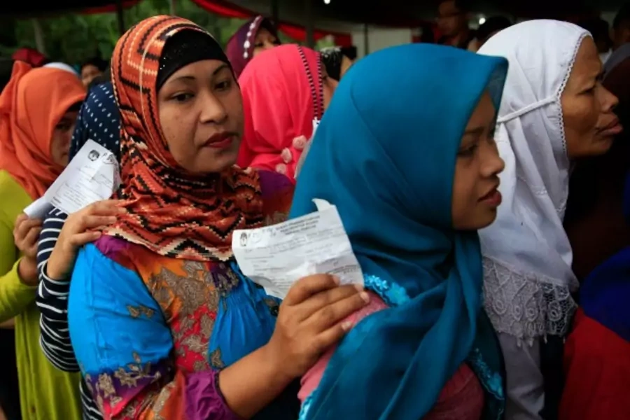 Villagers line up to vote in the country's presidential election at Bojong Koneng polling station in Bogor July 9, 2014. Indon...okowi" Widodo, who have been running neck-and-neck in opinion polls. REUTERS/Beawiharta (INDONESIA - Tags: POLITICS ELECTIONS)