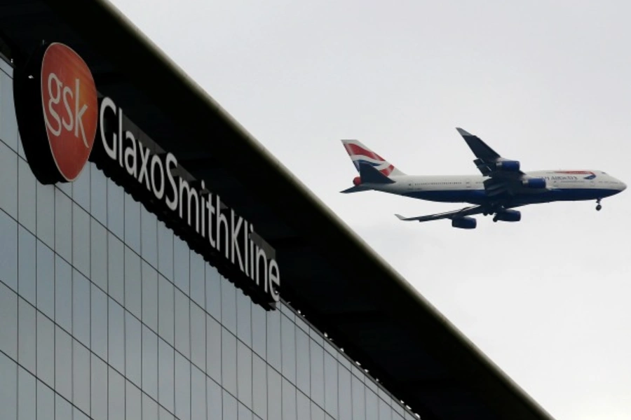 A British Airways airplane flies past a signage for pharmaceutical giant GlaxoSmithKline (GSK) in London on April 22, 2014. (Luke MacGregor/Courtesy Reuters)
