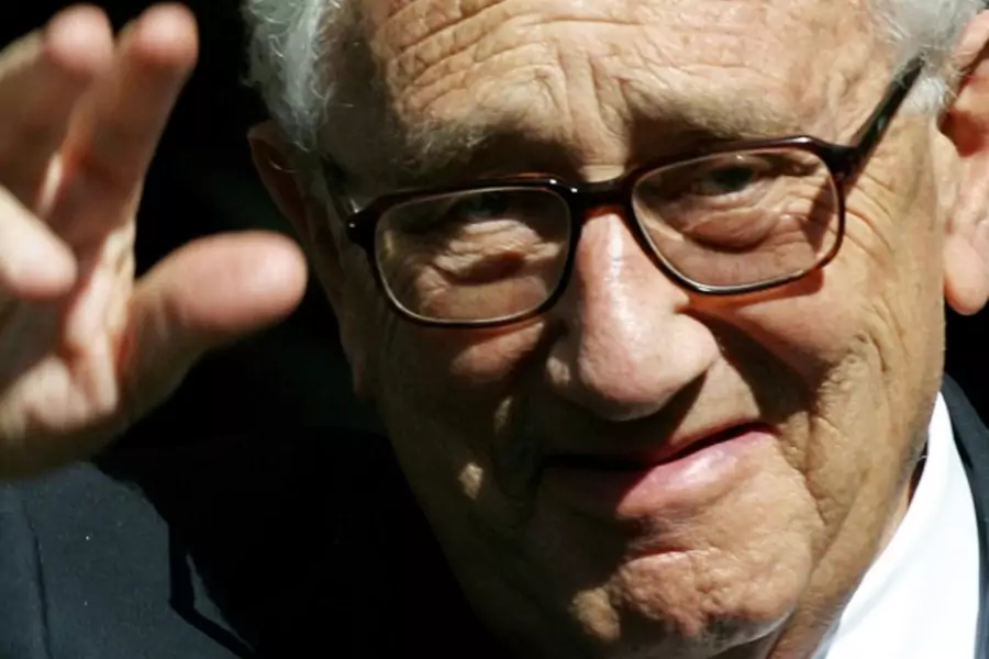 Former U.S. Secretary of State Dr. Henry Kissinger waves to the media as he leaves the Royal Albert Hall in London on April 24, 2002. (Kieran Doherty/Courtesy Reuters)