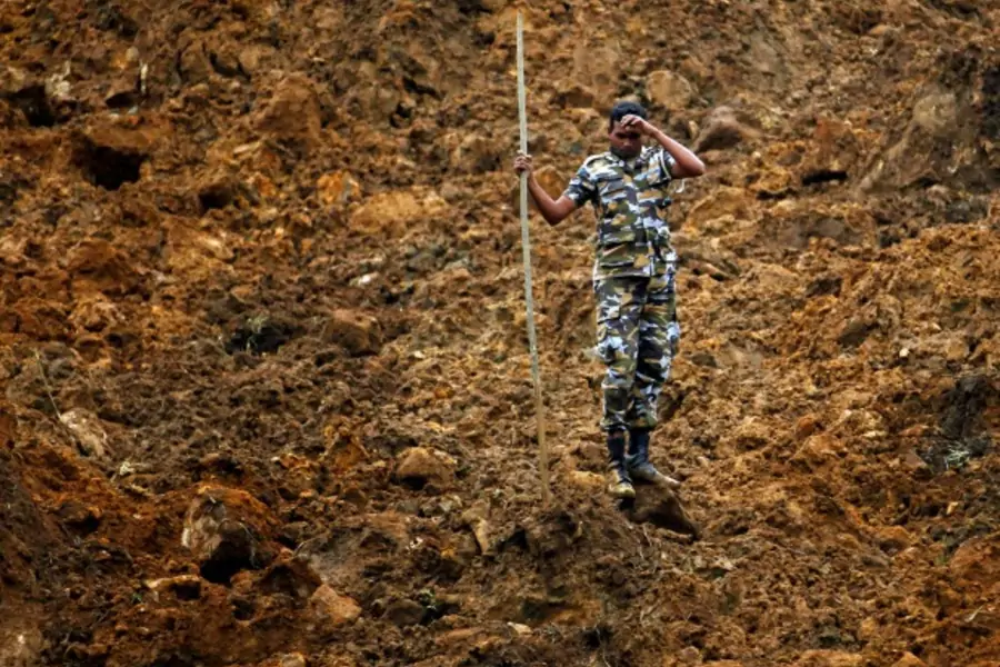A member of a military rescue team pauses during search operations at the site of a landslide at the Koslanda tea plantation near Haldummulla on October 30, 2014. (Dinuka Liyanawatte/Courtesy Reuters)
