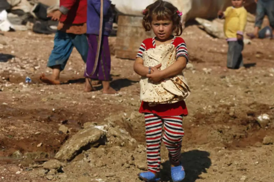 A Syrian girl carries bread in the Bab al-Salam refugee camp in Azaz, near the Syrian-Turkish border, October 27, 2014.