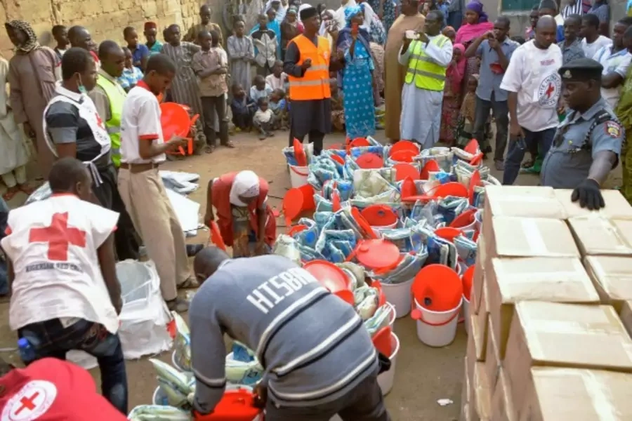 Displaced people gather as the Red Cross in Kano distributes relief materials to displaced victims of the Boko Haram violence, December 16, 2014. (Courtesy Reuters/Stringer)