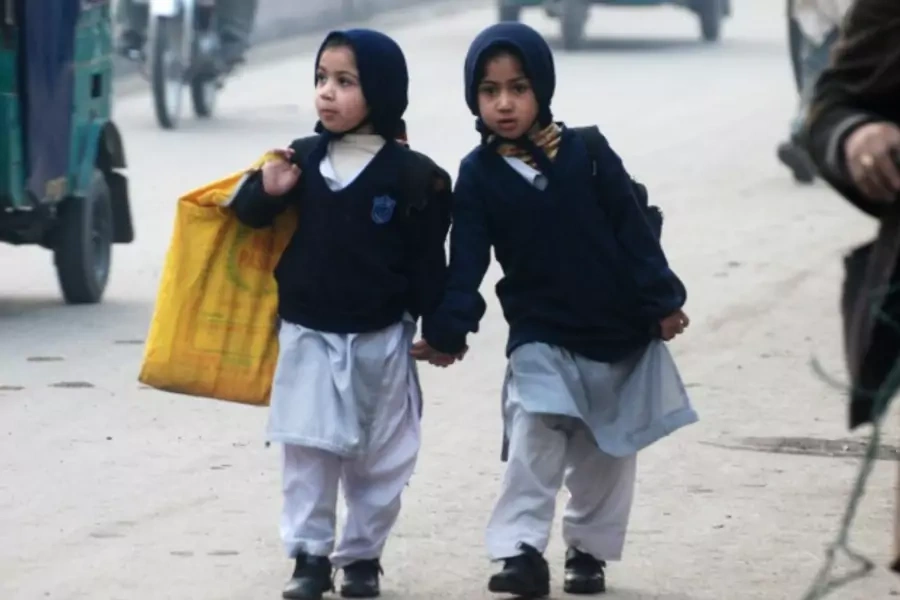 Girls carry their school bags as they walk along a road while heading to their school after it reopened in Peshawar, Pakistan, on January 12, 2015 (Courtesy Reuters/Khuram Parvez).
