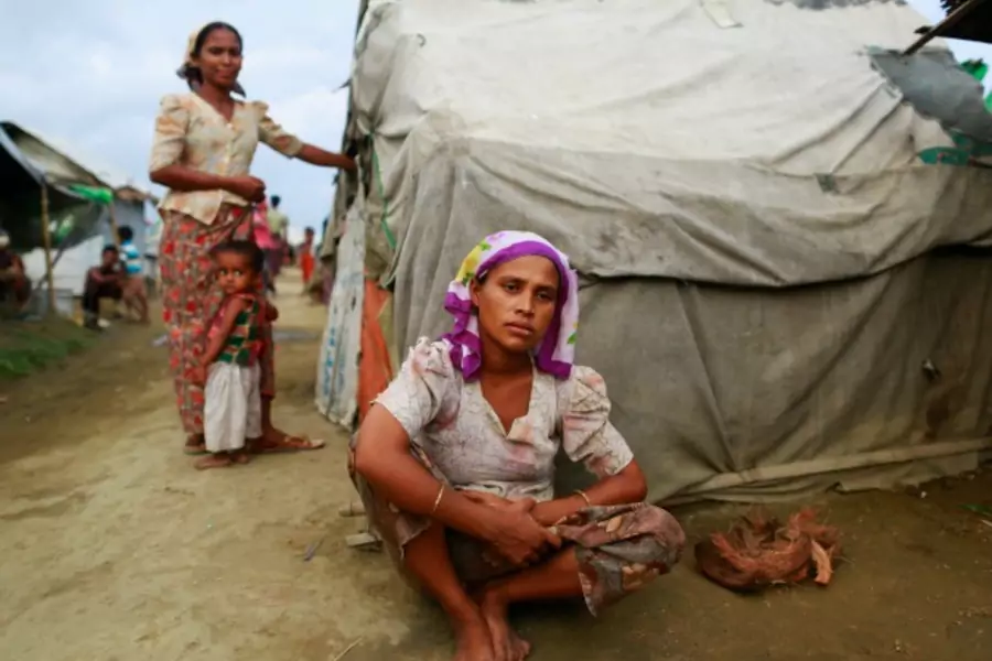 Sinnuyar Baekon, 25, sits in front of her hut at a refugee camp outside Sittwe, the capital city of the Rakhine state June 9, ...r homes. Picture taken June 9, 2014. REUTERS/Soe Zeya Tun (MYANMAR - Tags: SOCIETY IMMIGRATION POLITICS RELIGION CIVIL UNREST)