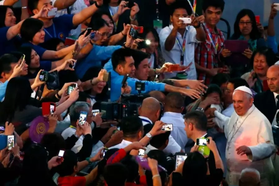Pope Francis waves to the Catholic faithful as he arrives for a meeting with Filipino families in Manila January 16, 2015. Pop... second and last leg of his week-long Asian tour. REUTERS/ Stefano Rellandini ( PHILIPPINES - Tags: RELIGION POLITICS SOCIETY)