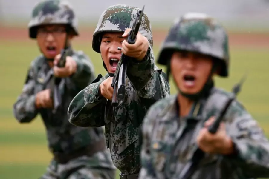 People's Liberation Army (PLA) soldiers shout as they hold guns and practise in a drill during a organized media tour at a PLA engineering school in Beijing, July 22, 2014. REUTERS/Petar Kujundzic (CHINA - Tags: MILITARY TPX IMAGES OF THE DAY)