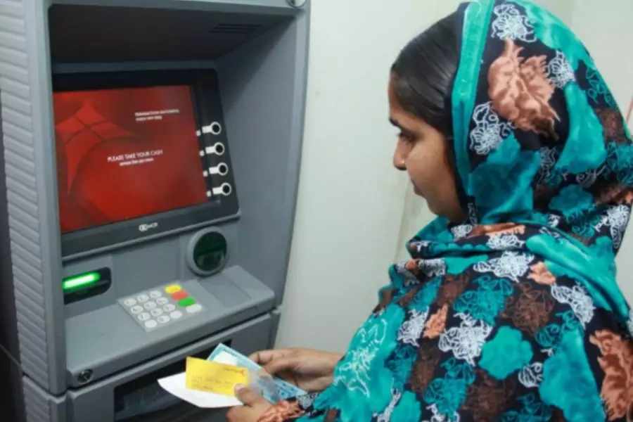 A worker uses an ATM newly installed in her factory in Dhaka, Bangladesh, June 2014 (Courtesy Camilla Fabbri/World Bank).