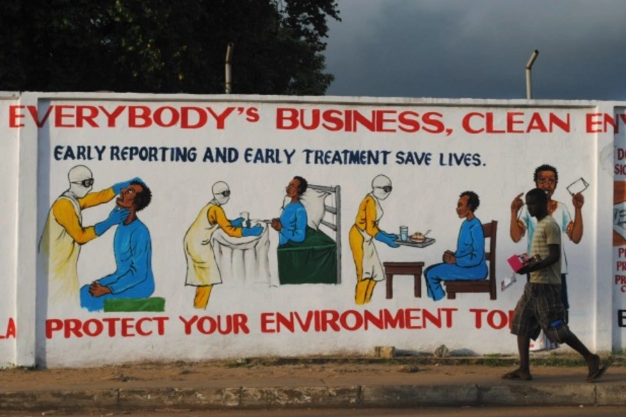 A man walks by a mural with health instructions on treating the Ebola virus, in Monrovia, November 18, 2014. (James Giahyue/Reuters)
