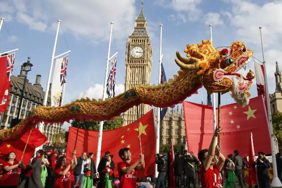 Supporters of China's President Xi Jinping perform opposite Big Ben in Parliament Square ahead of Xi's address to both Houses of Parliament, in London, Britain, October 20, 2015. Xi is on a State visit to Britain. REUTERS/Peter Nicholls
