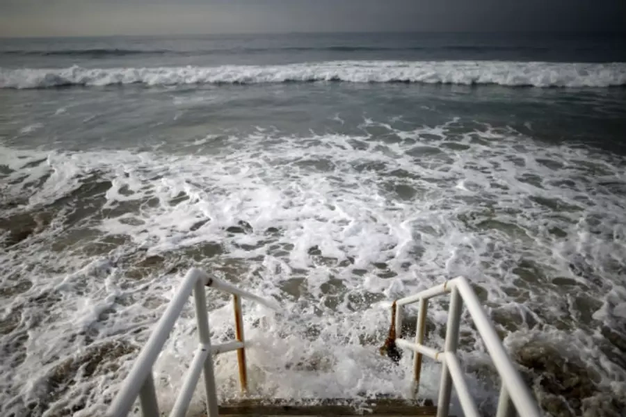 Waves crash against stairs to Broad Beach in Malibu, California, United States.