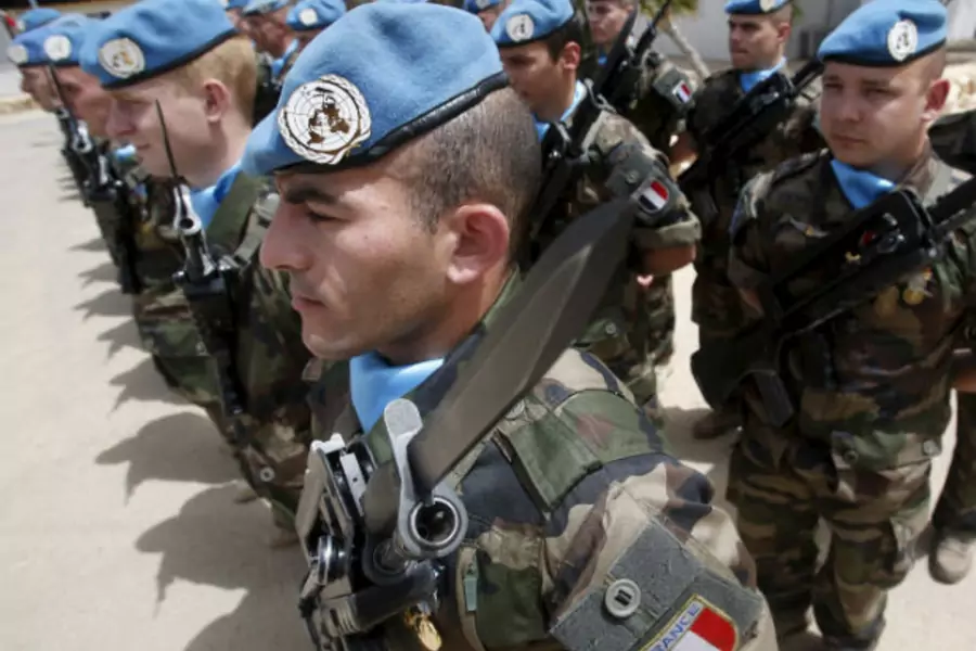 French peacekeepers of the United Nations Interim Force in Lebanon (UNIFIL) stand at attention during the visit of French Defense Minister Jean-Yves Le Drian to their base in Deir Kifa village in southern Lebanon on April 20, 2015.