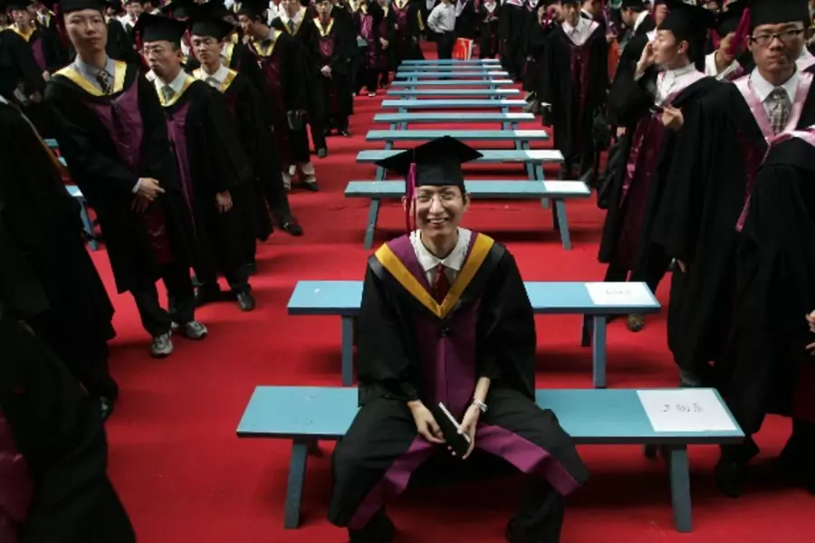 A student poses for a photo after a graduation ceremony at Tsinghua University in Beijing, July 11, 2006. About 4.1 million ar...o graduate this year, an increase of 22 percent over 2005, the official Xinhua news agency reported. REUTERS/Jason Lee (CHINA)