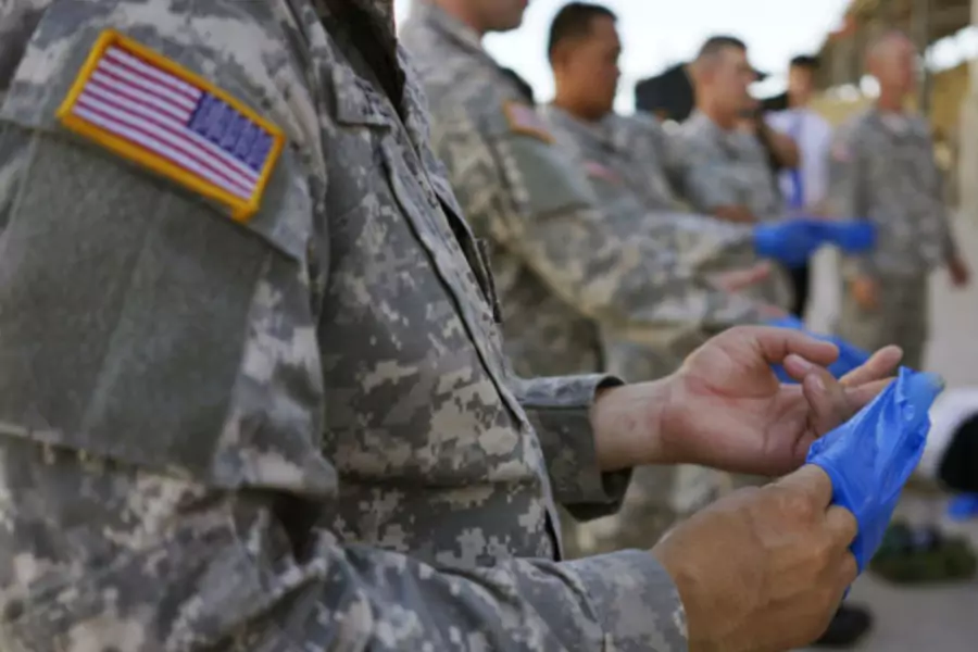 U.S. soldiers practice the proper way to remove protective gloves at Ft. Carson in Colorado Springs, Colorado, on October 23, 2014, prior to their deployment to Africa as part of the U.S. military response to the Ebola crisis.
